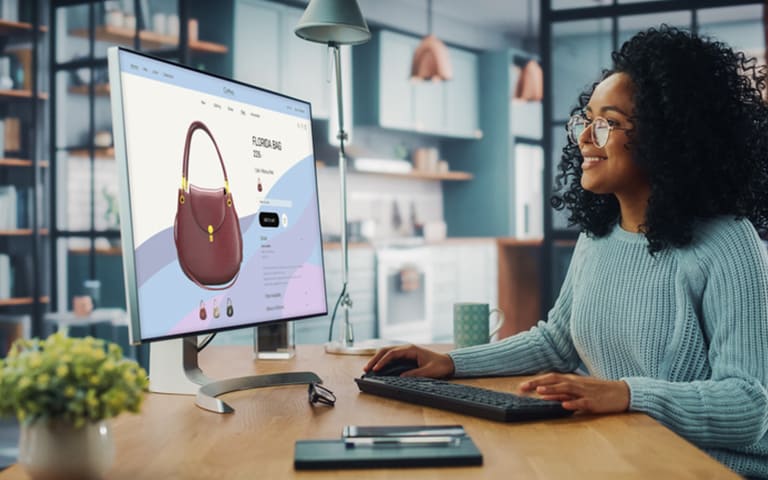 Femme utilisant un ordinateur de bureau avec des vêtements Boutique en ligne pour choisir et acheter des vêtements de la nouvelle collection