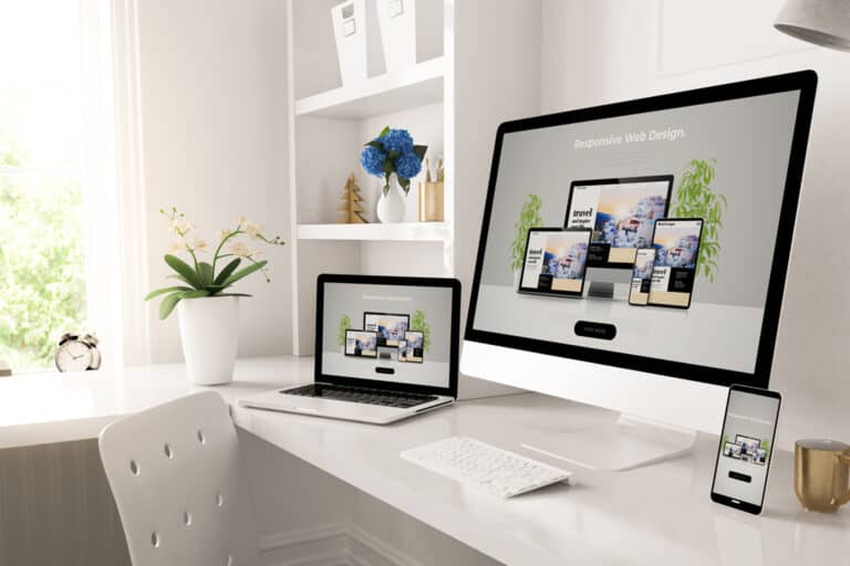 Un site internet sur différents supports (pc, tablette, smartphone) disposés sur un bureau blanc.
